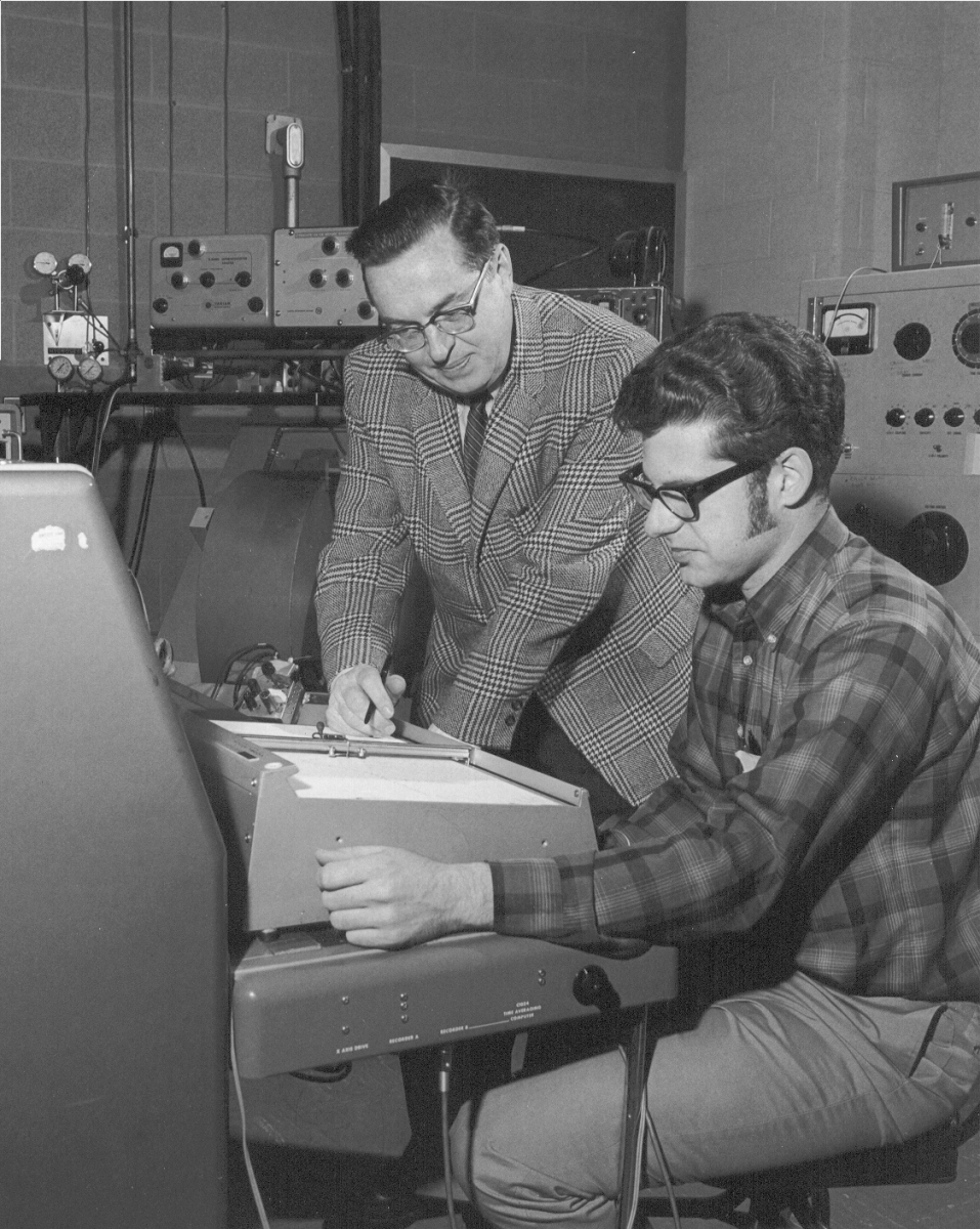 old image of Max T. Rogers helping a student with NMR